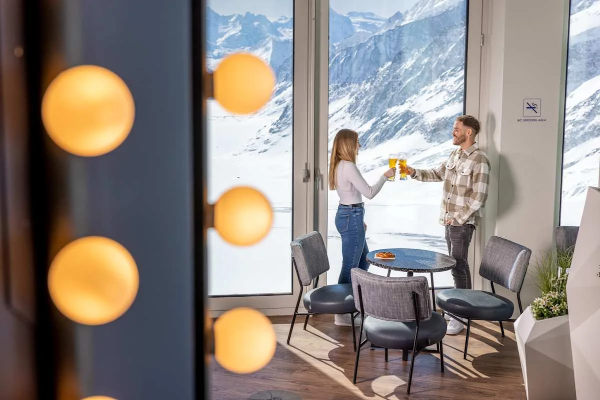Two people toasting by the windows of the Pikantus Lounge